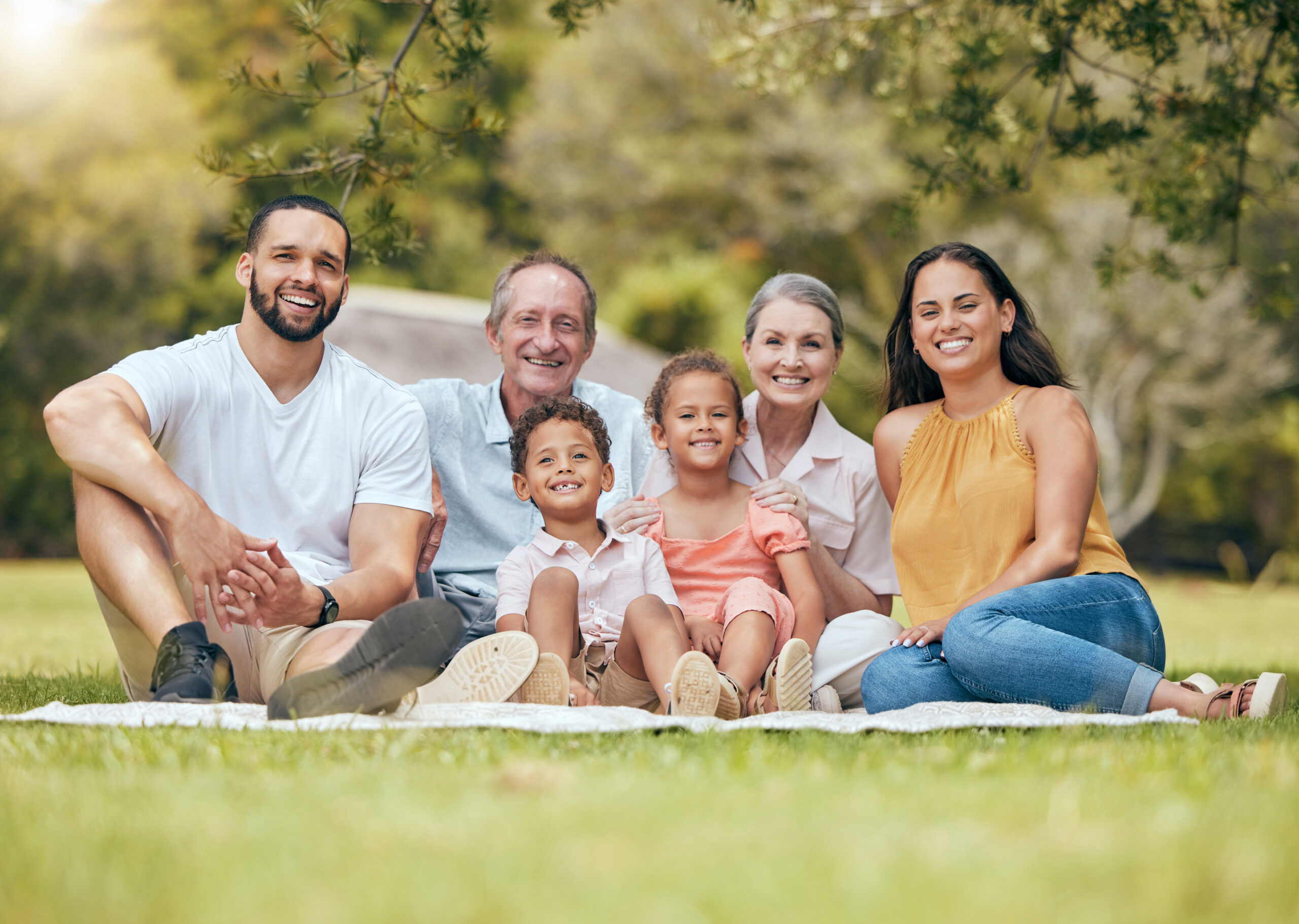 Familia multigeneracional en un parque disfrutando juntos, representando la protección que brinda un seguro de vida en Ecuador